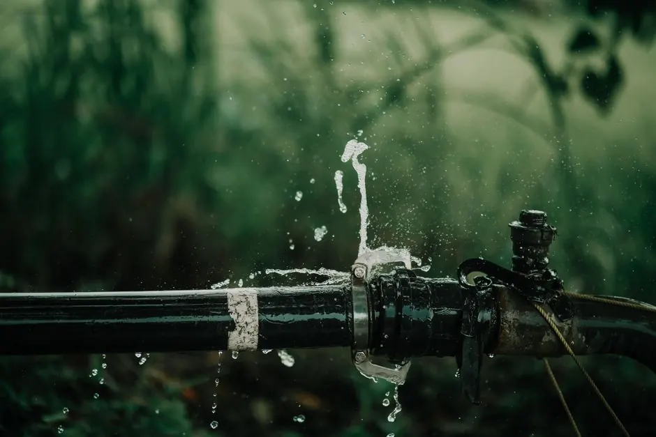 Leaking water pipe spraying water outdoors