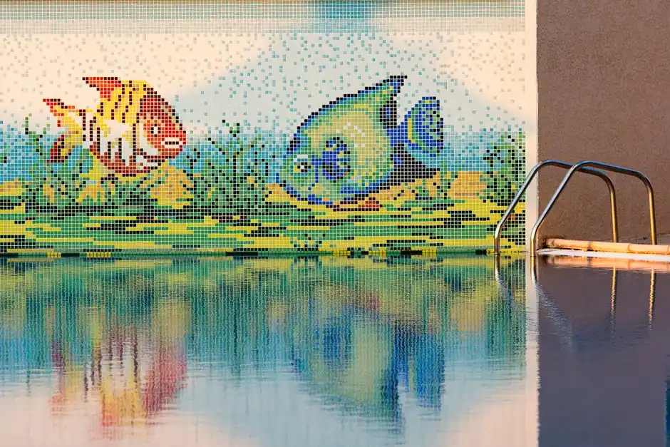 Mosaic fish tile at the edge of a swimming pool
