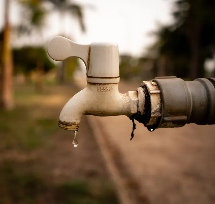 Brass outdoor tap with a drip forming at the spout