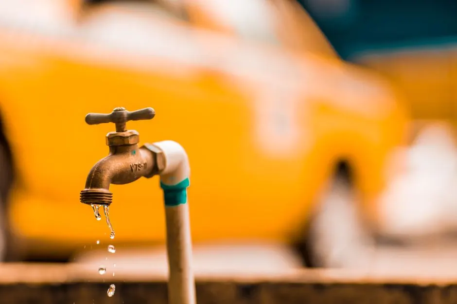 Brass faucet with water droplets in warm light