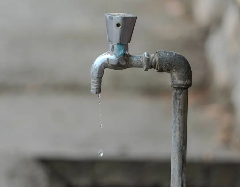 Outdoor faucet with a drip falling from the spout